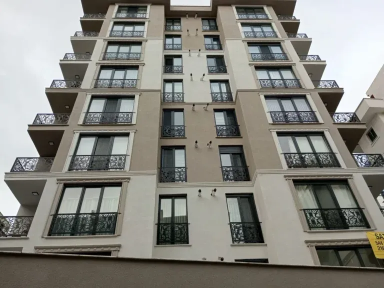 Balkonlarında ferforje korkuluklar olan çok katlı apartman cephesi