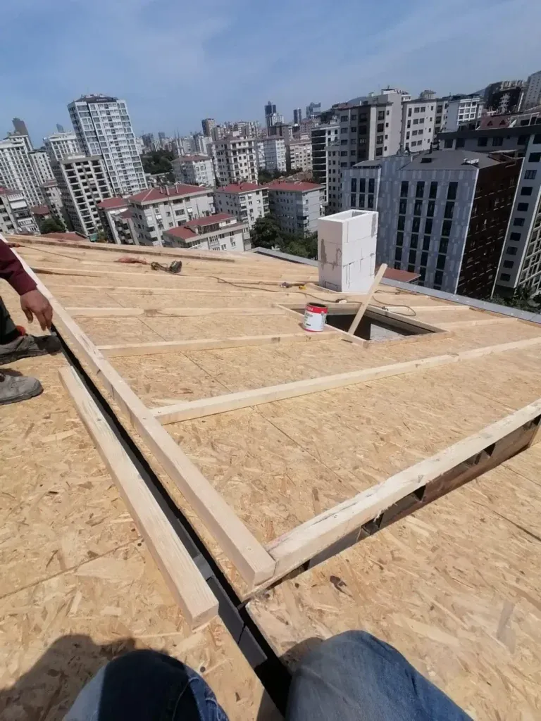 Şehir manzaralı bir çatıda OSB levhalarla kaplama çalışması